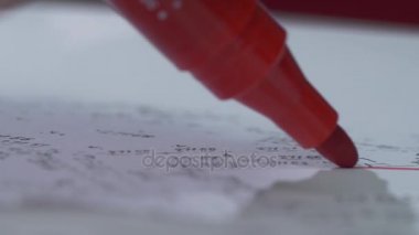 Kırmızı bir işaretleyici bir yaprak kağıda yazar. Yakın çekim. Marker ucu. Gölge ile kırmızı işaret