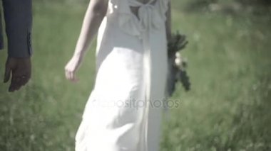 Düğün günü. Damat gelin el tutar, ormanın içinden yürüyorlar. Evli çift el ele tutuşarak closeup görünümü