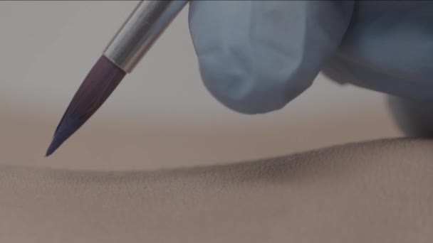 Tatoo au henné. Dessine un tatouage temporaire sur une jambe de femme. gros plan d'un artiste dessin à la main tatouage temporaire sur une jambe 