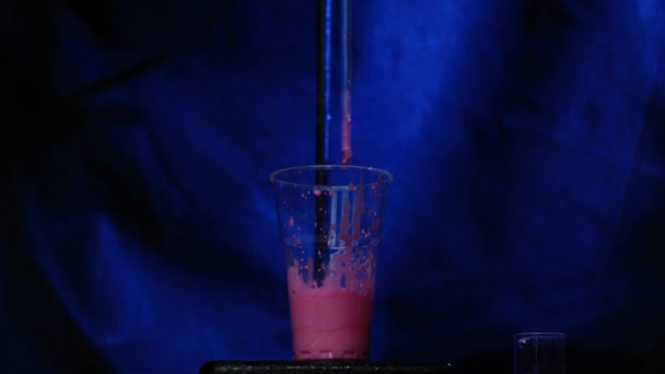Reazione chimica in flacone di vetro volumetrico in laboratorio. Il reagente chimico rosa in una bottiglia trasparente. Reazione chimica — Video Stock