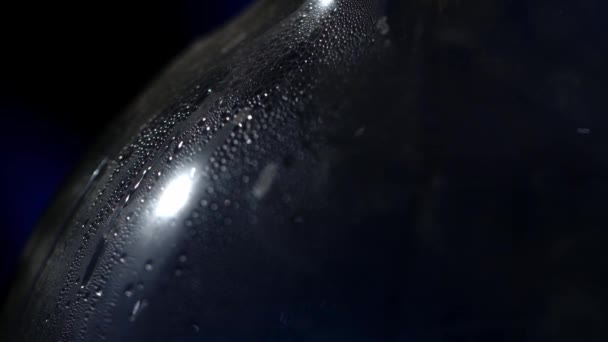 Grandes gotas de agua fluyen por el matraz gotas naturales de agua en el vaso, texturas de gotas de agua. Gotas fluyen a través de la macro bulbo — Vídeo de stock