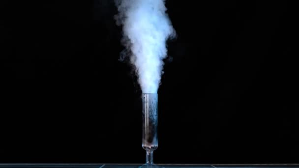 Measuring glass with smoke on a table of a chemical laboratory. Glass flask with chemicals and dry ice on a dark background — Stock Video