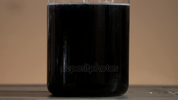 Tubo de ensayo de cerca. Líquido negro en el frasco. El líquido en el frasco cambia de color — Vídeos de Stock