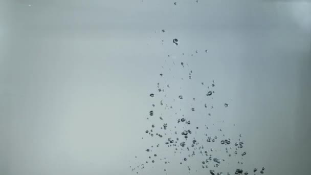 Fermer bulles d'eau sur fond gris verre. Bulles d'eau dans un récipient en verre. Vue rapprochée des gouttes en verre — Video