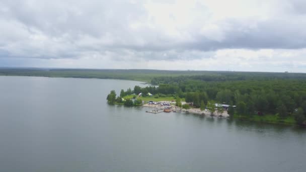 A kék tó, erdővel körülvett gyönyörű légifelvételek. A parton a tó, felülnézet, légi buja zöld erdő — Stock videók