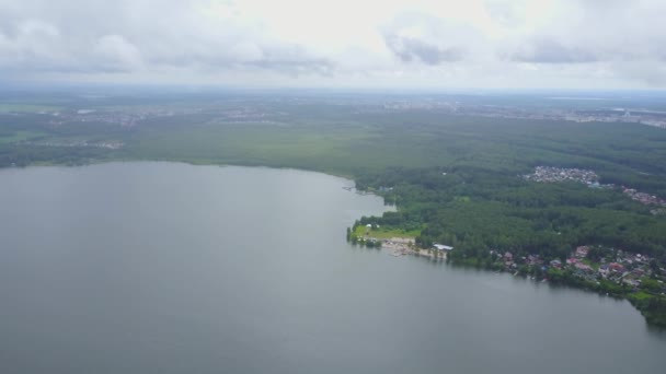 Прекрасний повітряний вид на блакитне озеро в оточенні лісу. Пишний зелений ліс на березі озера, вид зверху, повітря — стокове відео