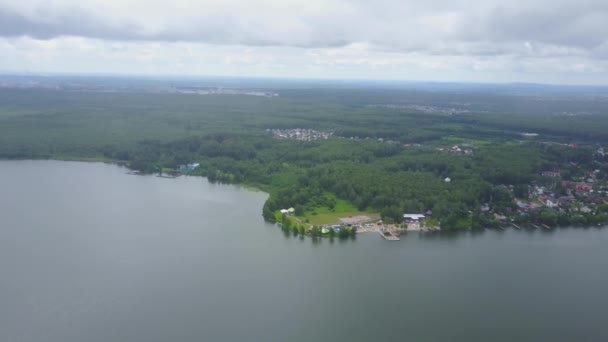 A kék tó, erdővel körülvett gyönyörű légifelvételek. A parton a tó, felülnézet, légi buja zöld erdő — Stock videók
