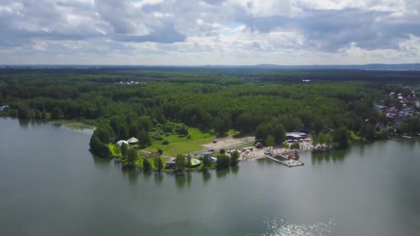 Göl kıyı liman hava görünümünü. Güzel hava görünümünü yukarıda. Çarpıcı Plajı manzaralı pier yürüyüş insanlarla. Plaj ve ormanı havadan görünümü — Stok video