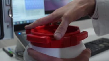 Kimyasal laboratuvar masada beyaz etiketlenmemiş plastik depo kapak açılarak kimyasal bilim adamı