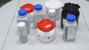 Bilim adamı beyaz bir kavanozu laboratuvarda alır ve onu uzağa taşır. Beyaz bir kavanoz tutan bilim adamı