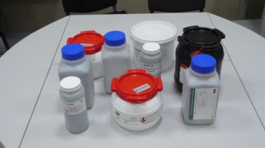 Bilim adamı beyaz bir kavanozu laboratuvarda alır ve onu uzağa taşır. Beyaz bir kavanoz tutan bilim adamı