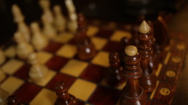 Jogo de xadrez, o jogador faz um movimento as peças brancas Bishop no tabuleiro Homem joga e faz movimento decisivo o Bispo. mão humana segurando figura de xadrez — Vídeo de Stock