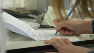 Closeup üstünde boş bir defter bir kalem ile yazılı bir el. Close-Up bir el üstünde boş bir defter bir kalemle yazma