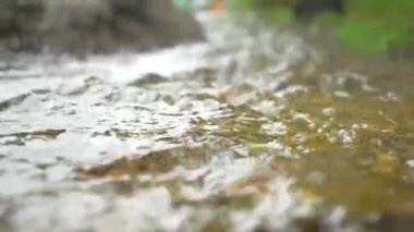 Taze ve temiz nehir suyu bir kaya akan. Seçici uygulanan odaklanarak. Küçük dere yeşil su seçici odak içinde su akan kabarcıkları doğal akışında dalgalanma. Su akışını