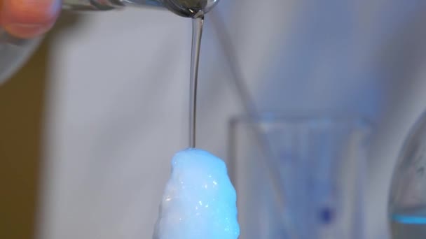 Kemiska experiment. Vätskan rinner från glaset till tabellen svart och omedelbart fryser. omedelbart frysning flytande — Stockvideo