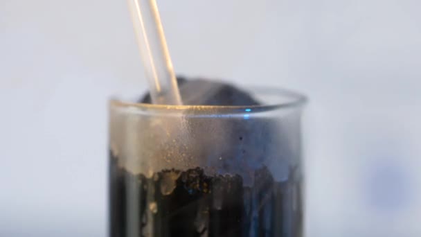 フラスコから黒の混合物。黒い背景にガラス フラスコ — ストック動画