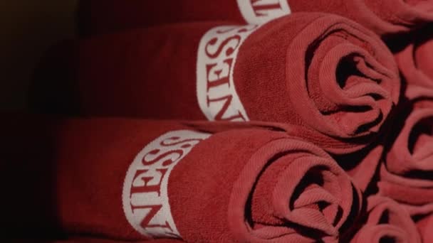 Toallas de spa enrolladas. Toallas rojas deportivas de cerca. Montón de toallas rojas — Vídeo de stock