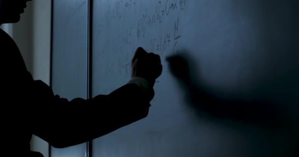 Wissenschaftler schreiben Formeln auf Kreidetafel. Hand mit Kreide schrieb Physikformeln auf schwarze Kreidetafel Nahaufnahme — Stockvideo