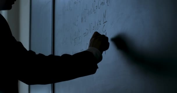 Cientista a escrever fórmulas no quadro. Mão com giz escreveu fórmulas de física em closeup quadro preto — Vídeo de Stock