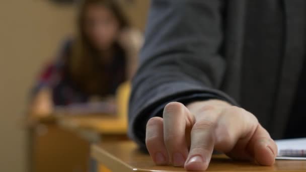 Студентська рука постукає впритул. Молодий чоловік торкається пальців на столі — стокове відео