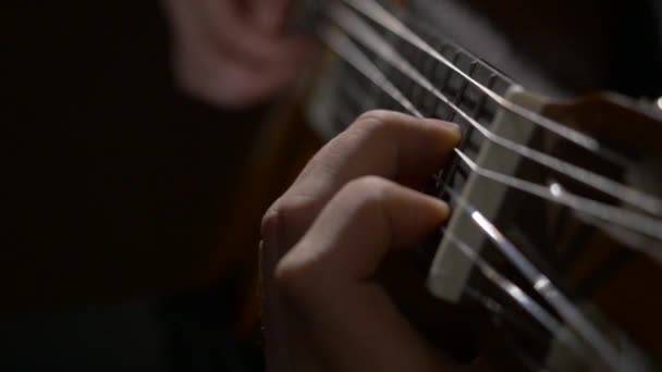 Närbild av gitarristen hand spelar akustisk gitarr. Nära upp skott av en man med fingrarna på banden av en gitarr som spelar — Stockvideo