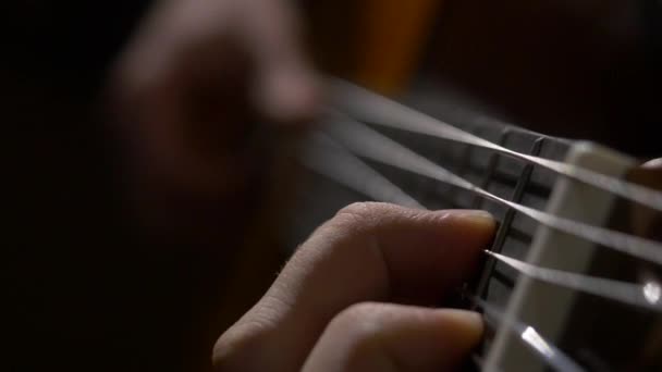 Close up da mão do guitarrista tocando guitarra acústica. Close up tiro de um homem com os dedos nos trastes de uma guitarra tocando — Vídeo de Stock