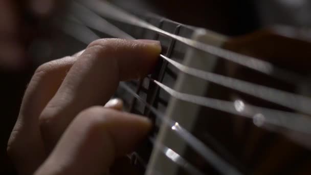 Primer plano del guitarrista tocando la guitarra acústica. Primer plano de un hombre con los dedos en los trastes de una guitarra tocando — Vídeos de Stock