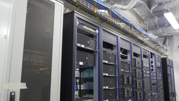 データで実行されている多くの強力なサーバー センターのサーバー ルーム。データ センター内の多くのサーバー。サーバー ルームに設置されたサーバーと多くのラック。複数の機器を明るく表示します。. — ストック動画