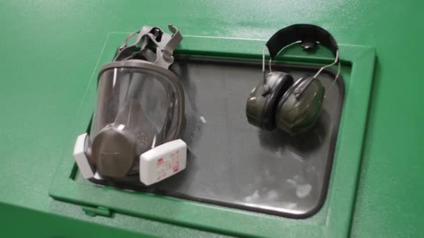 Respirador colgando de una caja de metal. Respirador y auriculares de cerca — Vídeos de Stock