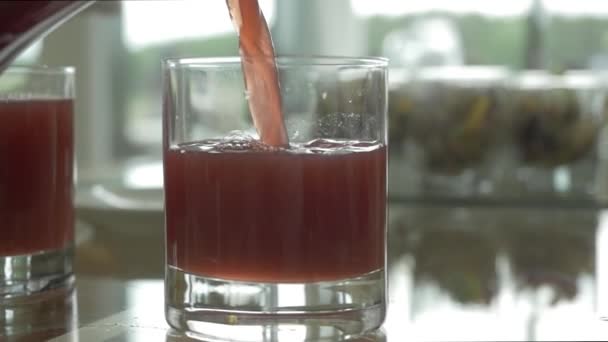 Mor üzüm suyu bir bardak dökme. Meyve içecek bir bardak içine dökme yakın çekim — Stok video