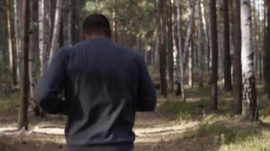 Orman yolda çalışan kas Çalıştırıcısı. Arkadan Görünüm. Orman yolda koşan atletik adam. Sonbahar orman ile iz üzerinde koşan atletik adam