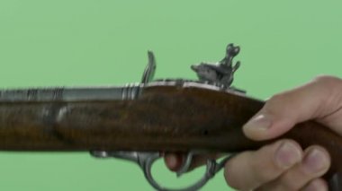 Adam eski bir tabanca ile. Yeşil ekranda izole vintage antik Çakmaklı tabanca. El sürgünler vintage silahın üzerinden mans