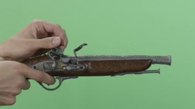Adam eski bir tabanca ile. Yeşil ekranda izole vintage antik Çakmaklı tabanca. El sürgünler vintage silahın üzerinden mans