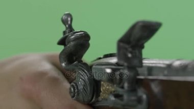 Vintage tabanca elinde yeşil arka plan üzerinde tutarak. Yeşil ekranda izole vintage antik Çakmaklı tabanca. Vintage silah atış yakın çekim