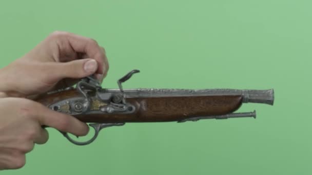 Az ember egy régi pisztoly. Vintage antik flintlock pisztoly elszigetelt zöld képernyő. Mans kézzel lő a fegyvert az évjárat — Stock videók