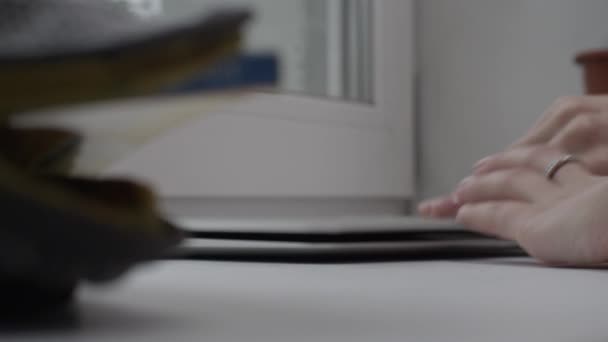 Zavřete pracovní rukou na notebooku na panoramatické okno. Žena pracující na notebooku na okenní parapet — Stock video
