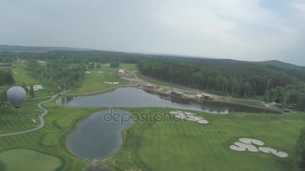 Bovenaanzicht groene golfbaan buiten groen grasveld. Luchtfoto van drone vliegen — Stockvideo