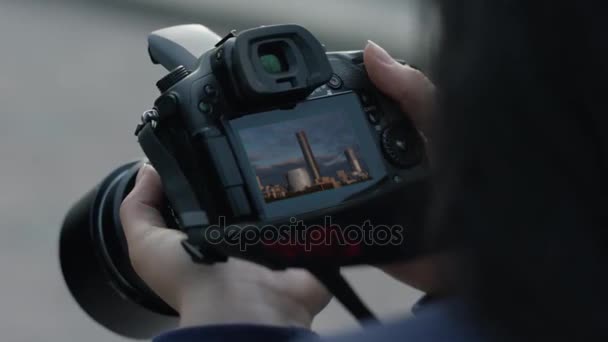 Fotógrafa chica disparando imágenes. manos de mujer sosteniendo la cámara tomando fotos. Chica mira a la pantalla de la cámara — Vídeo de stock