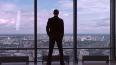 Bel, Ceo üzerinde tam uzunlukta arkadan görünüm takım ayakta eller ofiste başarılı iş adamı. Şehir Manzaralı penceresinde önünde arkasından işadamı
