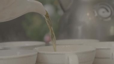 Çay çay fincan içine dökülür varlık. Su ısıtıcısı çay bardak içine dökülen.