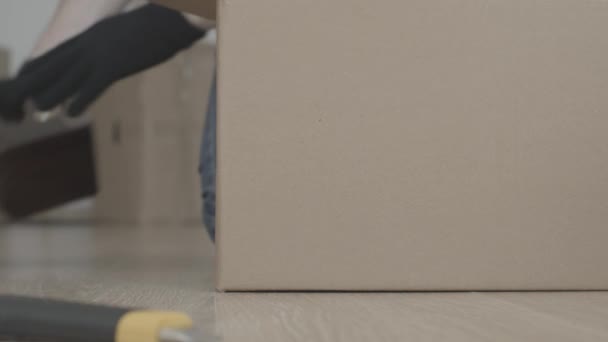 Man takes things out of the box. Flips the box and pours the contents — Stock Video