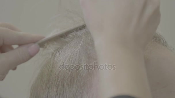 Primer plano de un peluquero que usa tijeras para afeitarse la cabeza de sus clientes — Vídeo de stock
