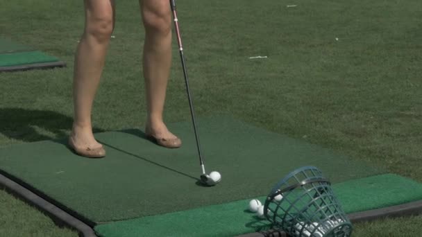 Mladá žena golfového hráče školení na zelené s klubem. Dívka kopnout do míče — Stock video