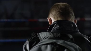 Arkadan Görünüm ceketli yakışıklı adamı ararken suitcas ile seyahat. Arka görünüm insanlar koleksiyonu. kişinin arka görünümü. Adam bir ceket ve çanta arkadan görünüm siyah arka planda