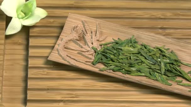 Glass teapot with blooming tea flower inside against wooden background Chinese green tea leaves close up in traditional cup. tea ceremony. Chinese tea, ceremony — Stock Video