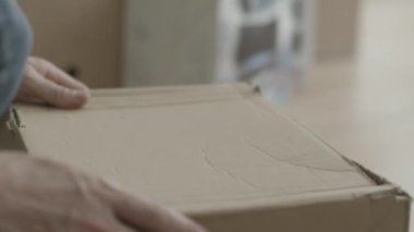 Adam kutudan bir çekiç çeker. Ev yenileme yapan erkek ve kutunun dışında bir çekiç çeker