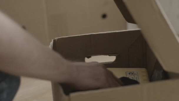 Adam kutudan bir çekiç çeker. Ev yenileme yapan erkek ve kutunun dışında bir çekiç çeker — Stok video