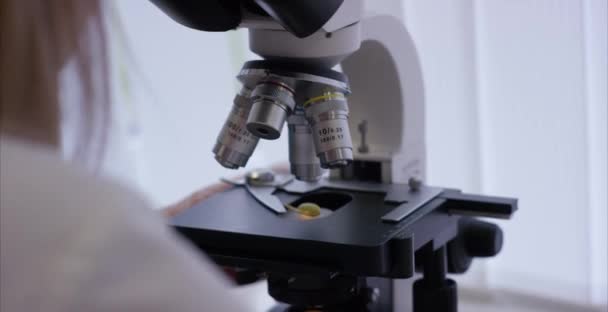 深刻な臨床実験室で化学要素を勉強します。顕微鏡レンズのクローズ アップ。マイクロ分析の準備を顕微鏡スライドのサンプル — ストック動画