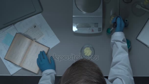 Recherche chimique dans les boîtes de Pétri. Chercheur préparant des plaques de couleur dans un laboratoire de microbiologie. Main d'un technicien inoculant des plaques. Vue de dessus. Homme scientifique pendant le travail à la biologie moderne — Video