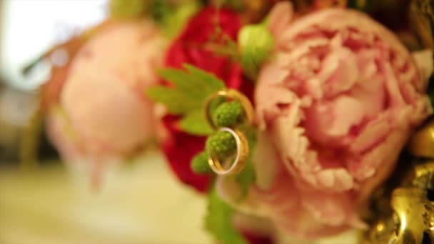 Snubní prsteny a růžové růže kytice. Snubní prsteny na svatební kytici. Snubní prsteny na kytici růží. — Stock video